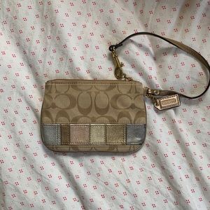 Tan authentic Coach wristlet with metallic accents